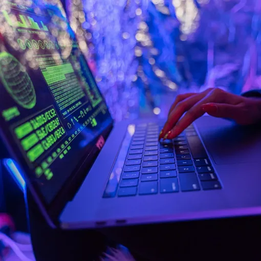 Developer coding on a laptop with custom software interface, representing Stellar Digital Media’s custom web development and support services.