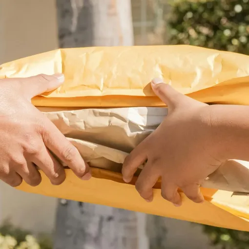 Hands exchanging ecommerce delivery packages, representing Shopify store fulfilment and support services.