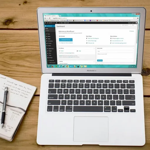 WordPress dashboard on laptop with notes and coffee representing website development and support